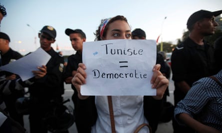 A woman holds a sign during a protest against the Islamist Ennahda movement in Tunis