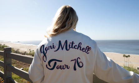 Amy Key in a white jacket with ‘Joni Mitchell tour 76’ on the back. 