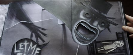 An open spread of the picture book from the film, showing the Babadook monster looming over a small female figure lying down on the floor, wearing white. 