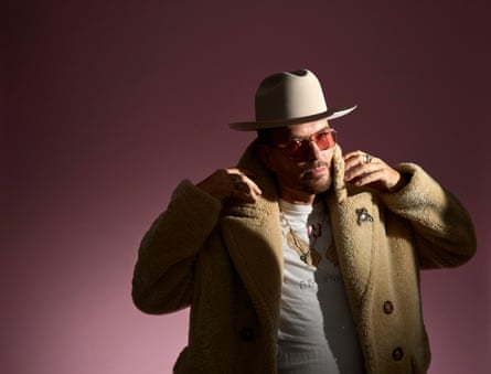 Goss in heavy sheepskin coat, orange-lens sunglasses and Stetson, looking a bit like Fat Joe.