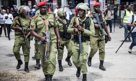 Armed police, some wearing helmets, on the street