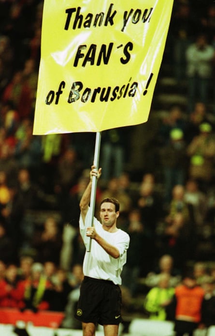 Borussia Dortmund’s Paul Lambert displays a banner saying “Thank you fans of Borussia” after their November 1997 Champions League match against Parma, his final game for the German club.