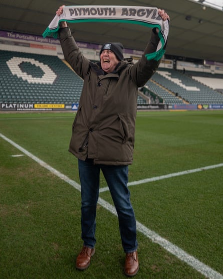 Jed Griffiths raises a Plymouth Argyle scarf at Home Park. 