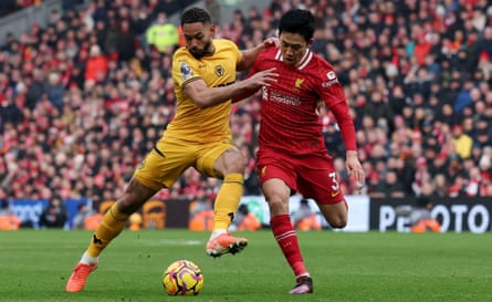 Wataru Endo and Matheus Cunha tussle for the ball at Anfield