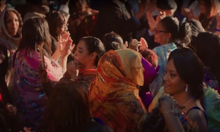 Women in colourful robes dance and smile