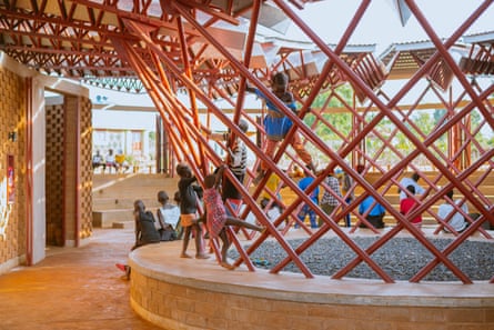 Children climb on a lattice structure inside the Bidi Bidi centre