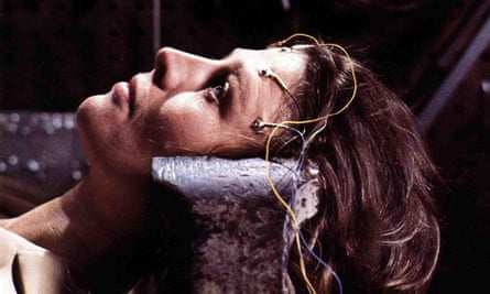 Julie Christie lying down with her head clamped in position and wires attached to her forehead in Demon Seed 