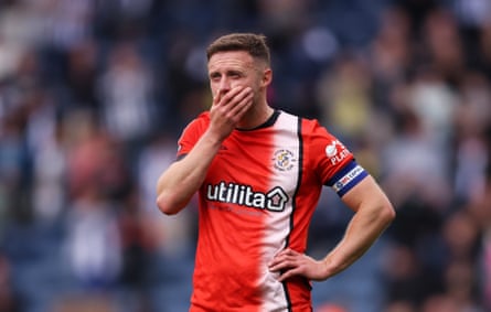 Luton’s captain, Jordan Clark, looks dejected after defeat confirmed their fall to League One.